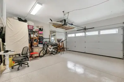 a garage with a white garage door and a bike at Steps to Lido Village and the Marina Heart of Lido Island WITH PARKING in Newport Beach