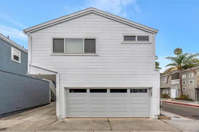 a white house with a garage at Steps to Lido Village and the Marina Heart of Lido Island WITH PARKING in Newport Beach