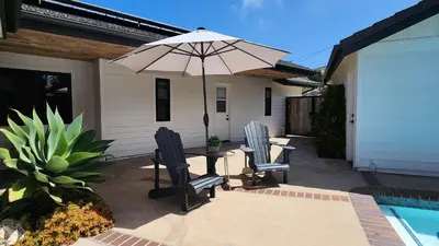 a patio with two chairs and a table with an umbrella at Ocean Views Beach House - 40 PCT Off Monthly in San Clemente