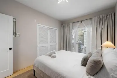 a bedroom with a large white bed and a window at City Lights and Rooftop Nights by Rather Be Properties in San Diego