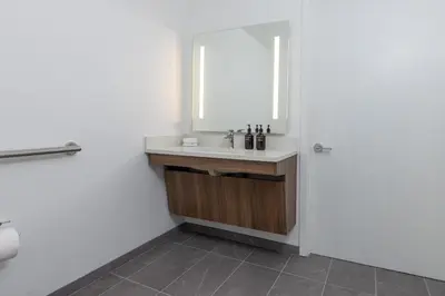 a bathroom with a sink and a mirror at Kasa Little Italy San Diego in San Diego