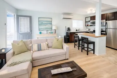 a living room with a couch and a kitchen at Charming Ocean Beach 2BR in San Diego