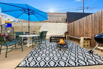 a patio with a fire pit and a blue umbrella at Charming Ocean Beach 2BR in San Diego