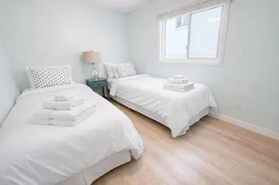 two white beds in a room with a window at Charming Ocean Beach 2BR in San Diego