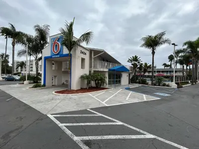 a hotel parking lot with a gas station at Studio 6 San Diego, CA Hotel Circle Mission Valley in San Diego
