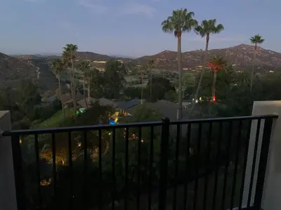 a balcony with a view of palm trees and mountains at New Constructed Home in Poway in Poway