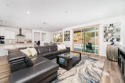 a living room with a leather couch and a kitchen at Allura Champagne New in Wine Country Pool Game Room in Country Road Estates