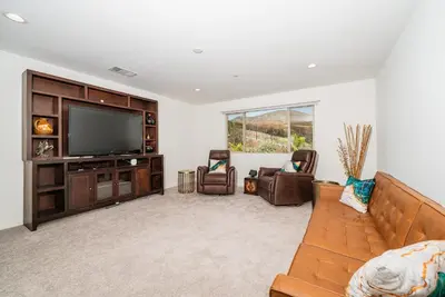 a living room with a couch and a flat screen tv at Allura Champagne New in Wine Country Pool Game Room in Country Road Estates