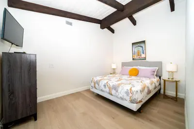 a bedroom with a bed and a flat screen tv at Casa Via Zara - Sweeping Mountain Views with Pool in Fallbrook