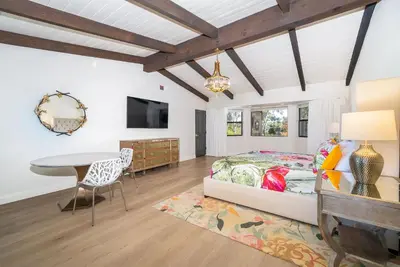 a bedroom with a bed and a table at Casa Via Zara - Sweeping Mountain Views with Pool in Fallbrook