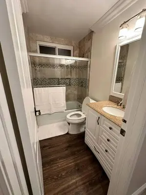 a white bathroom with a toilet and a sink at Anselmo in Mission Viejo