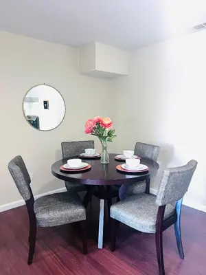 a dining room table with chairs and a vase of flowers at Calligraphy home with Private Deck near SDSU in San Diego