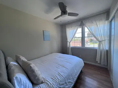 a bedroom with a bed and a ceiling fan at Calligraphy home with Private Deck near SDSU in San Diego