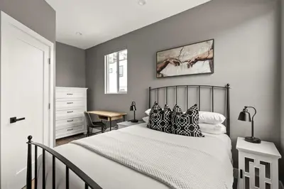 a bedroom with a bed and a desk in it at Brand New Coastal Contemporary in Pacific Beach in San Diego