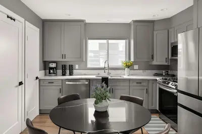 a kitchen with a table with chairs and a sink at Brand New Coastal Contemporary in Pacific Beach in San Diego