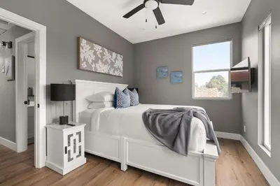 a bedroom with a white bed with a ceiling fan at Brand New Coastal Contemporary in Pacific Beach in San Diego