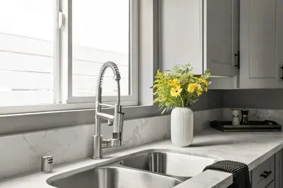 a kitchen sink with a vase of yellow flowers at Brand New Coastal Contemporary in Pacific Beach in San Diego