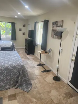 a bedroom with a bed and a desk and a lamp at Casa Mesa PLUS attached Studio & private Courtyard in San Diego