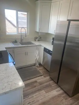 a kitchen with white cabinets and a stainless steel refrigerator at Casa Mesa PLUS attached Studio & private Courtyard in San Diego