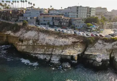 an aerial view of cars parked on a cliff next to the ocean at Spectacular La Jolla Cove Compound in San Diego
