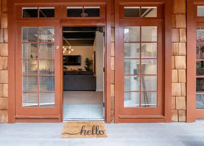 a pair of doors to a building with a welcome mat at Gorgeous Villa Steps to La Jolla Cove in San Diego