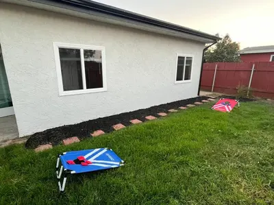 two umbrellas sitting in the grass in front of a house at NEW CA Coastal Beauty 6 mins to Imperial Beach in San Diego
