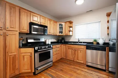 a kitchen with wooden cabinets and stainless steel appliances at Hillcrest 3 bedroom charming private home by shops & restaurants in San Diego