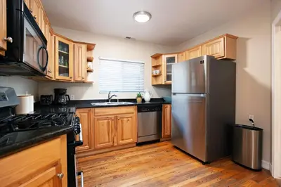 a kitchen with wooden cabinets and a stainless steel refrigerator at Hillcrest 3 bedroom charming private home by shops & restaurants in San Diego