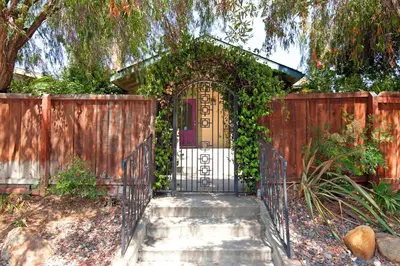 a gate in a fence with ivy on it at Hillcrest 3 bedroom charming private home by shops & restaurants in San Diego