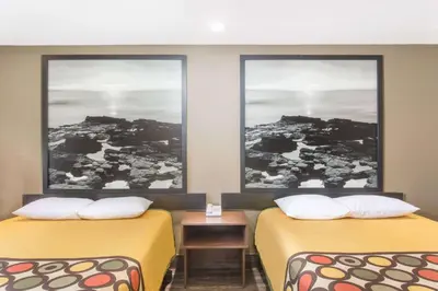 two beds in a room with two windows at Super 8 by Wyndham National City Chula Vista in National City