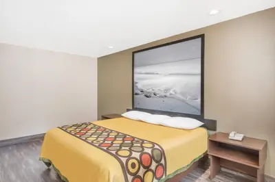 a hotel room with a bed and a picture on the wall at Super 8 by Wyndham National City Chula Vista in National City