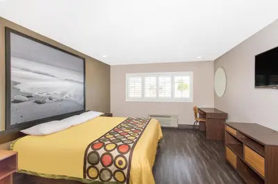 a hotel room with a bed and a flat screen tv at Super 8 by Wyndham National City Chula Vista in National City