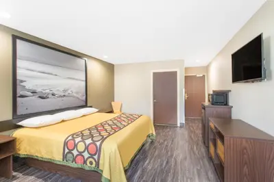 a hotel room with a bed and a flat screen tv at Super 8 by Wyndham National City Chula Vista in National City