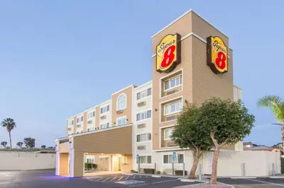 a hotel with two signs on the side of a building at Super 8 by Wyndham National City Chula Vista in National City