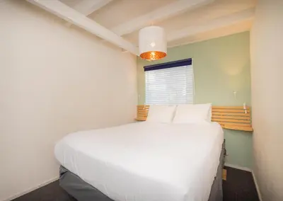 a large white bed in a room with a window at Sandy Toes in San Diego