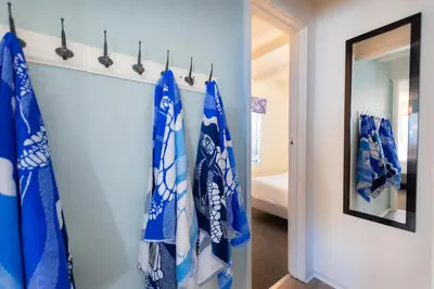 a hallway with blue and white towels on a wall at Sandy Toes in San Diego