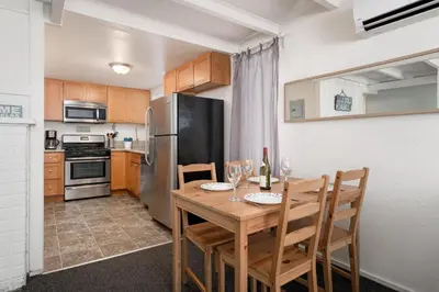 a kitchen with a table with chairs and a refrigerator at Sandy Toes in San Diego