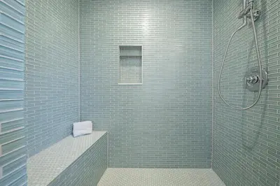 a bathroom with a shower with blue tiles at Shores Perfection in San Diego