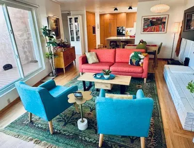 a living room with a red couch and blue chairs at Shores Perfection in San Diego
