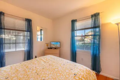 a bedroom with a bed and two windows at PuertAzul in San Diego