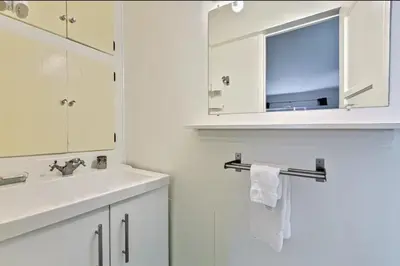 a white bathroom with a sink and a mirror at PuertAzul in San Diego