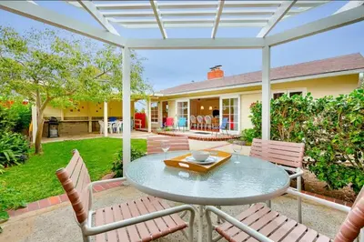 a patio with a table and chairs and a house at PuertAzul in San Diego