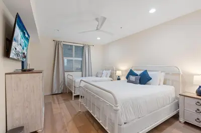 a bedroom with two beds and a flat screen tv at Blissful Retreat in San Diego