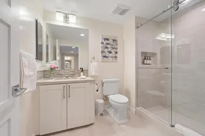 a white bathroom with a shower and a toilet at Blissful Retreat in San Diego