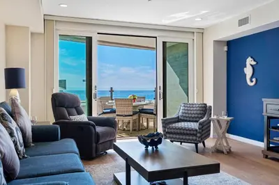 a living room with a couch and chairs and the ocean at Blissful Retreat in San Diego