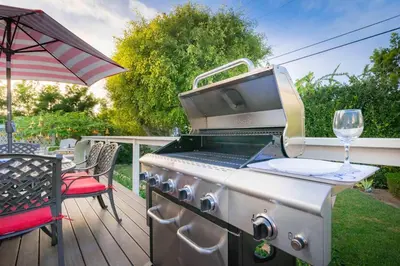 a grill on a deck with a glass of wine at Las Palmas Escape in San Diego