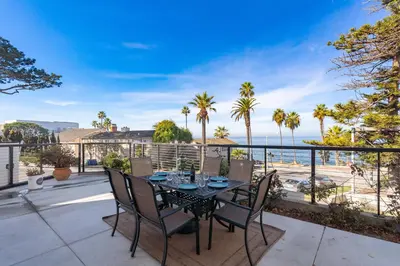 a table and chairs on a balcony with a view of the ocean at Coastal Overlook in San Diego