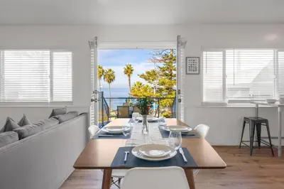 a dining room with a table and a view of the ocean at Coastal Overlook in San Diego