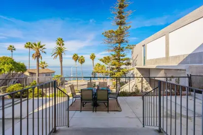 a balcony with a table and chairs and the ocean at Coastal Overlook in San Diego