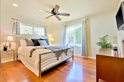 a bedroom with a bed and a ceiling fan at Sandy Shores Beach House in San Diego